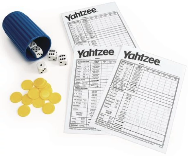 The contents of a Yahtzee set - dice, shaker, score cards, and bonus chips.